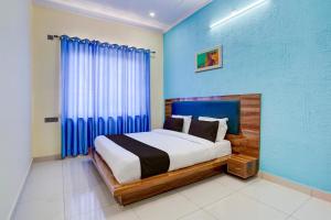 哈尔德瓦尼OYO HOTEL STAY INN的一间卧室配有一张蓝色墙壁的床