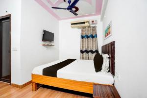 兰纳加OYO Premier Jim Corbett Home Stay的一间卧室配有一张床和一台电视。