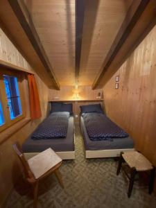 UrmeinHaus Maran的小房间设有两张床和椅子