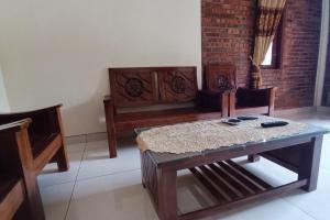 日惹OYO 93839 Aquenda Homestay的客厅配有木桌和椅子