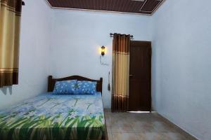 日惹Capital O 93842 Jowo Segoro Resort的一间卧室设有床、窗户和门