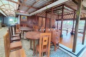 日惹Capital O 93842 Jowo Segoro Resort的用餐室配有木桌和椅子