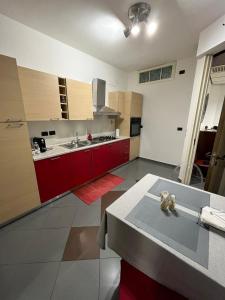 巴里Casa Garruba Central Station的一间厨房,里面装有红色橱柜和一张桌子