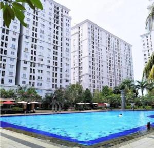 雅加达OYO 93857 Apartemen Kalibata City By Artomoro的一座大型游泳池,位于高楼前