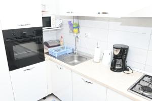 默克斯卡Apartment Oscar的白色的厨房配有水槽和微波炉