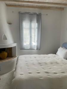 阿基奥斯·索斯蒂斯·米科诺斯Mykonian 4 Bd Ocean Dream House in Agios Sostis的白色的卧室设有床和窗户