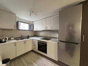 安坡里奥圣托里尼Emporio New Classic 1Bd Santorini Stylish Apt的厨房配有白色橱柜和不锈钢冰箱