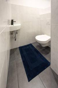 维也纳Second District Charming Flat的浴室配有卫生间、水槽和蓝色地毯。