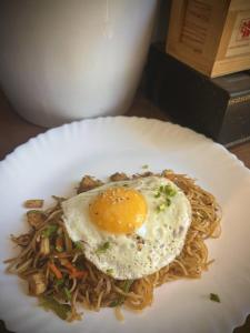 RongliAshraya Boutique Homestay的面条上带鸡蛋的食品盘