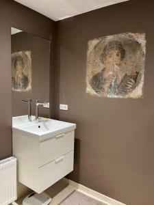 克森Barrierefreie schöne Wohnung im EG的一间带水槽的浴室和墙上的绘画