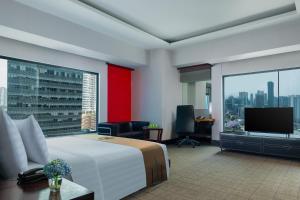 雅加达曼哈顿雅加达酒店的配有一张床和一台平面电视的酒店客房