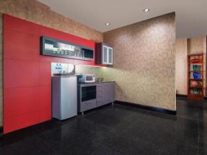 雅加达曼哈顿雅加达酒店的带冰箱和红色墙壁的厨房