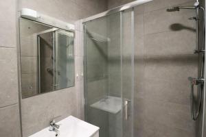 都柏林Inviting 2-Bed Apartment in Dublin的带淋浴、盥洗盆和镜子的浴室