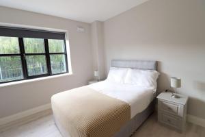 都柏林Inviting 2-Bed Apartment in Dublin的白色的卧室设有床和窗户