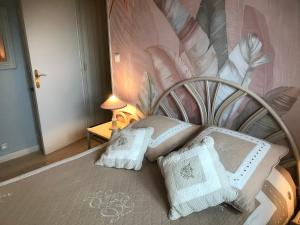 Le Breuil-en-Auge低谷乡村民宿的一间卧室配有带枕头的床和蝴蝶壁纸