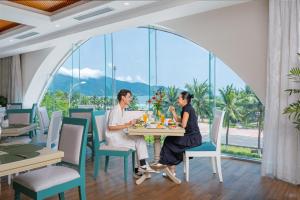 岘港Paracel Beach Hotel的坐在餐厅桌子上的两名妇女