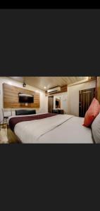 孟买Hotel Green Park的酒店客房设有一张大床和一台电视。