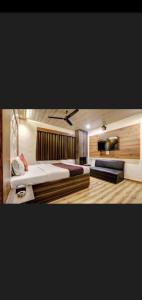 孟买Hotel Green Park的一间卧室配有一张大床和一台平面电视