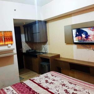当格浪OYO 93831 Penginapan Cisauk的客房设有厨房,墙上配有电视。