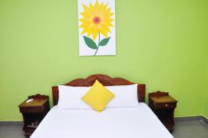 科伦坡Sea View Hotel的卧室配有一张挂有花卉画的床铺。