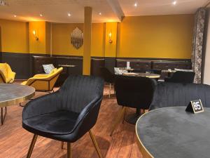 布雷斯特罗吉思酒店的餐厅设有黑色的桌椅和黄色的椅子