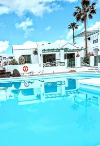 卡门港金合欢公寓式酒店的一座带房子的游泳池