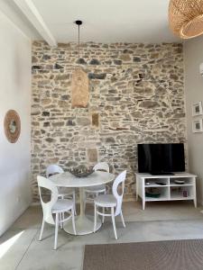 Saint-GervasyAppartement cosy avec terrasse的一间设有桌椅和石墙的用餐室