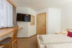 福尔施陶威克赫特酒店的一间卧室配有一张床、一张书桌和一台电视