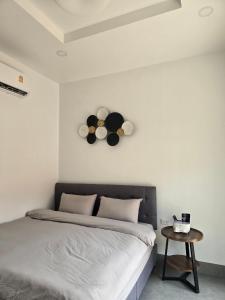 Ban SuanAiranda Phuket Homestay的卧室配有一张床,墙上挂着一个钟
