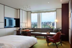 东京东京虎之门之丘安达仕酒店的酒店客房,配有床和沙发