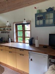 Uggerby桑德加德农家乐的厨房配有蓝色橱柜和木制台面