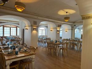 弗里希利亚纳弗里希利亚纳别墅酒店的餐厅设有木桌、椅子和窗户。