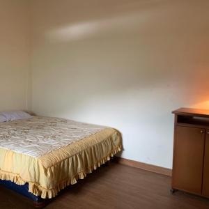 里奥班巴Casa Campo Juive Grande的一间卧室配有一张床和一个木制梳妆台