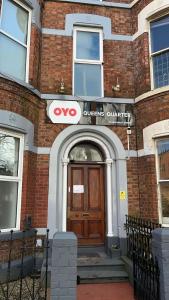 贝尔法斯特OYO Queens Quarter的砖房的前门,上面有Wvu标志