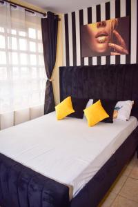 内罗毕Kahawa sukari luxury home的一张黄色和黑色枕头的床