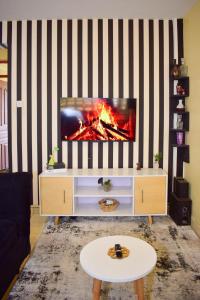 内罗毕Kahawa sukari luxury home的一间带电视和壁炉的客厅