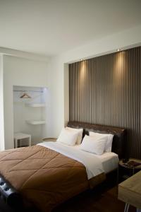 雅典雅典弥诺阿酒店的卧室配有带白色枕头的大床
