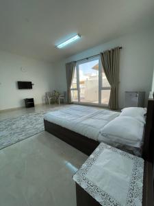 Al Khawḑللإيجار استوديوهات ضمن فيلا جديده كلياً的一间卧室设有两张床和大窗户