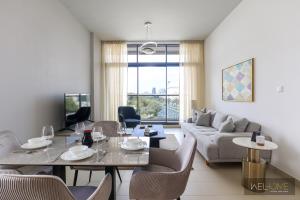 迪拜WelHome - Prime 1BR Apartment at Oia Residence的客厅配有桌子和沙发