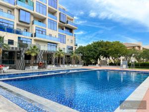 迪拜WelHome - Prime 1BR Apartment at Oia Residence的大楼前的游泳池