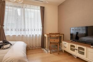 东京Felice Nishi-Shinjuku的一间卧室配有一张床和一台平面电视
