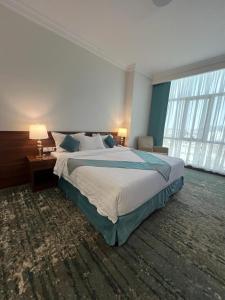 麦地那Zaha Al Madina Hotel的一间卧室设有一张大床和一个大窗户