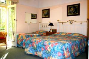 墨尔本乔治亚廷床和早餐旅馆的一间卧室配有两张床和一张带台灯的桌子