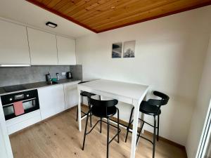 KrattigenEva's Seeblick的厨房配有白色的桌子和黑色的椅子