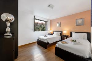 卢加诺Villa Dolce Vita With Private Pool - Happy Rentals的酒店客房设有两张床和窗户。