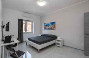 钱皮诺Travelershome Ciampino Airport GuestHouse的一间卧室配有一张床、一张书桌和一个窗户。