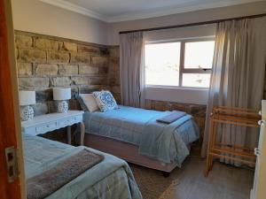 MaclearZamenkomst River Lodge的一间卧室设有两张床和窗户。
