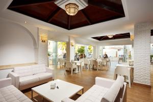 内尔哈Hotel Villa Flamenca的餐厅设有白色的沙发和桌椅