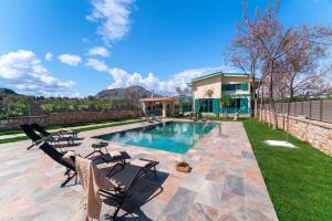 科林比亚Serenity Villas的一个带两把椅子的游泳池以及一座房子