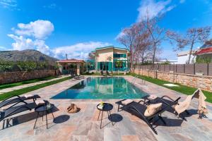 科林比亚Serenity Villas的一个带椅子的游泳池以及一座房子